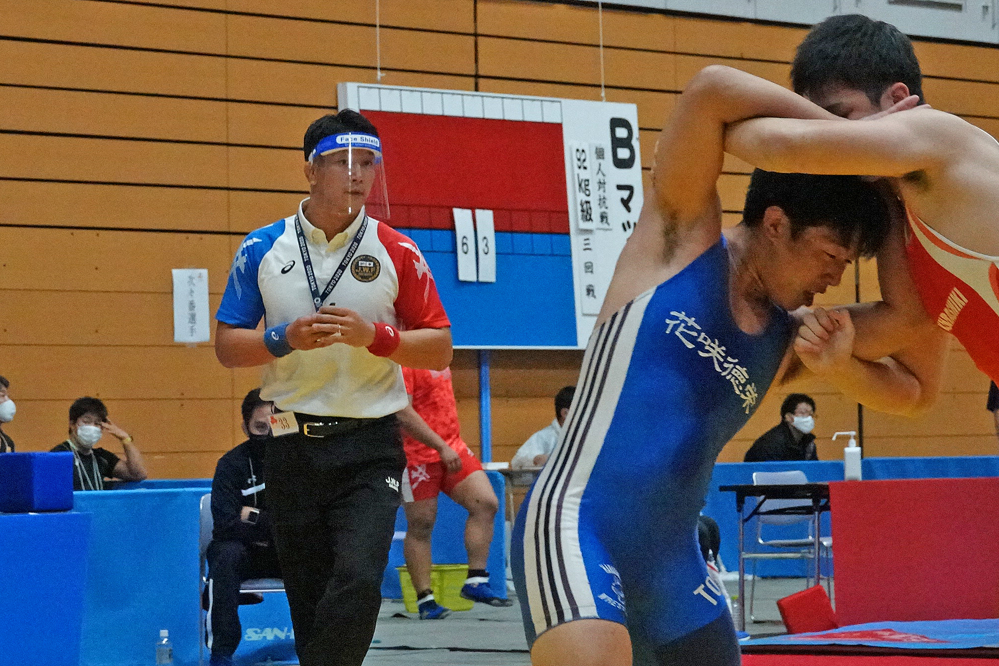 A referee wearing a face shield keeps an eye on the action. (Japan Wrestling Federation photo)